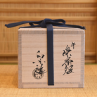Inscribed wooden storage box for the Kawasaki Waraku Shiro Raku matcha bowl, secured with a dark blue tying cord.