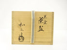 Exterior view of the wooden storage box with paper band for the pre-owned Kawasaki Waraku Black Raku matcha bowl.
