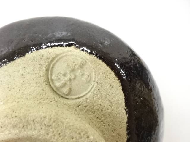 Close-up detail of the underside of the Kawasaki Waraku Black Raku matcha bowl showing the foot and impressed mark.