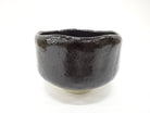Front view of the pre-owned Kawasaki Waraku Black Raku matcha bowl with a rounded form and glossy black glaze.