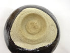 Underside view of the pre-owned Black Raku matcha bowl showing the unglazed foot and base.