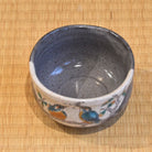 Angled top view of the Kawasemi matcha bowl showing its speckled blue-gray interior and painted kingfisher decoration around the exterior.