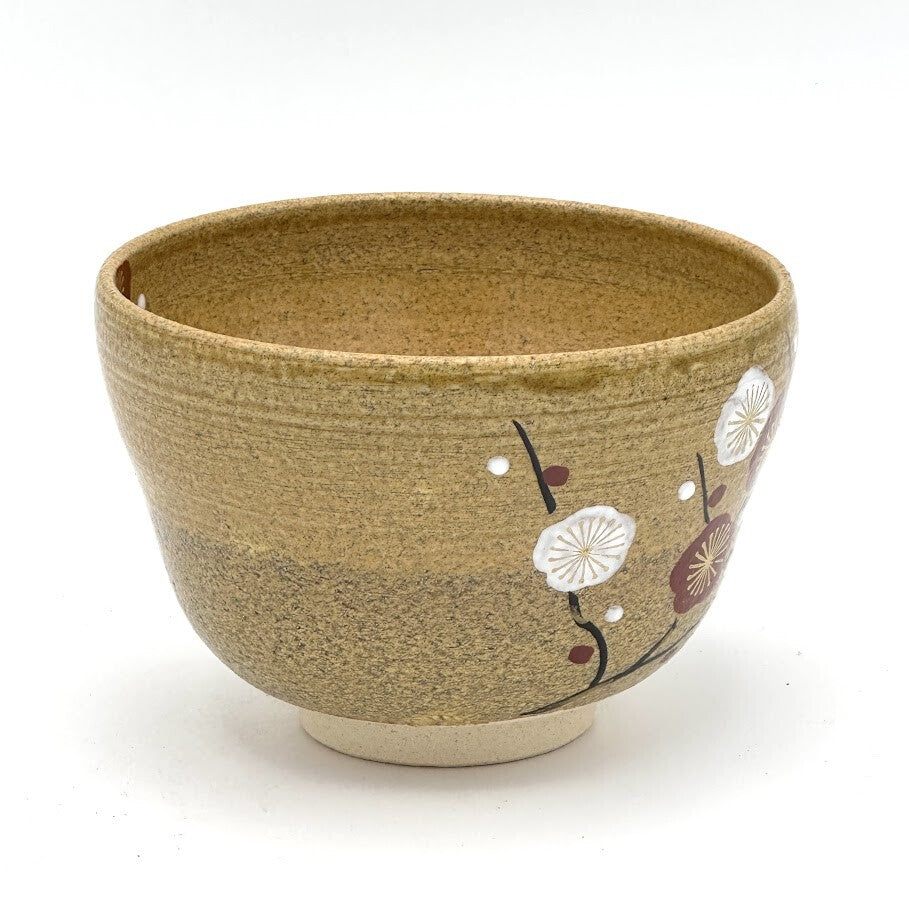 Side view of the hand-painted Kiyomizu-yaki chawan showing delicate white plum blossoms and dark branches against the textured brown glaze