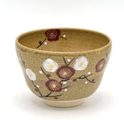 Hand-painted Kiyomizu-yaki matcha bowl featuring an Eda-Ume plum branch motif with white and deep red blossoms on a warm brown glaze