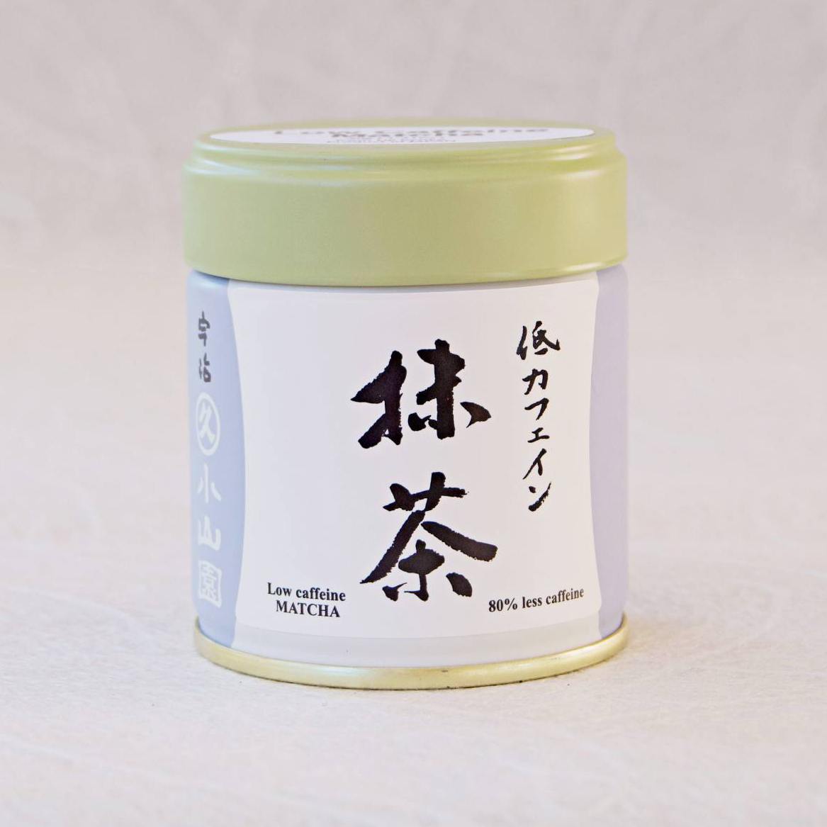 Cylindrical container of matcha tea with Japanese text on a light gray background
