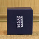 Blue box with a white label on a woven background