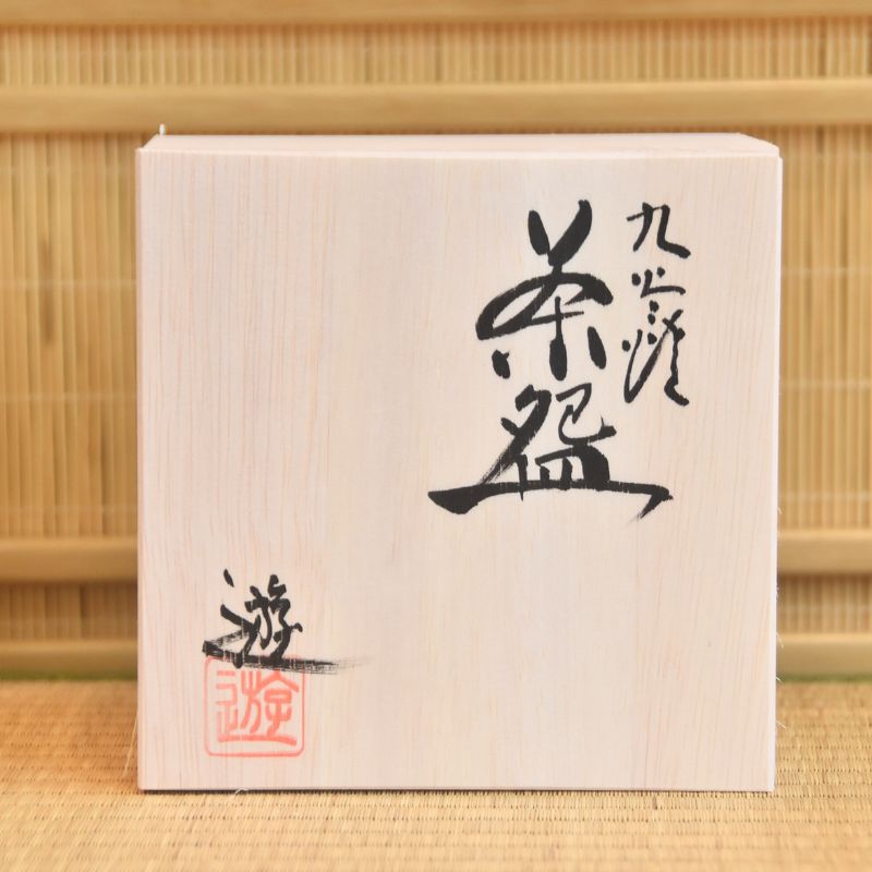 Wooden box with Japanese calligraphy on a bamboo background