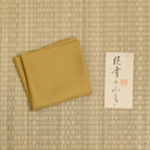 Kuwazome Mustard Yellow Silk Fukusa displayed on tatami, handcrafted in Kyoto for Japanese tea ceremony.