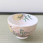 Top interior view of the Kyo-yaki Akikusa chawan showing the soft pink glaze, sweeping green grasses, gold leaf moon, and colorful autumn flowers