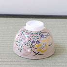 Underside view of the Kyo-yaki Akikusa matcha bowl showing its ceramic foot and hand-painted autumn flowers, grasses, and gold accents