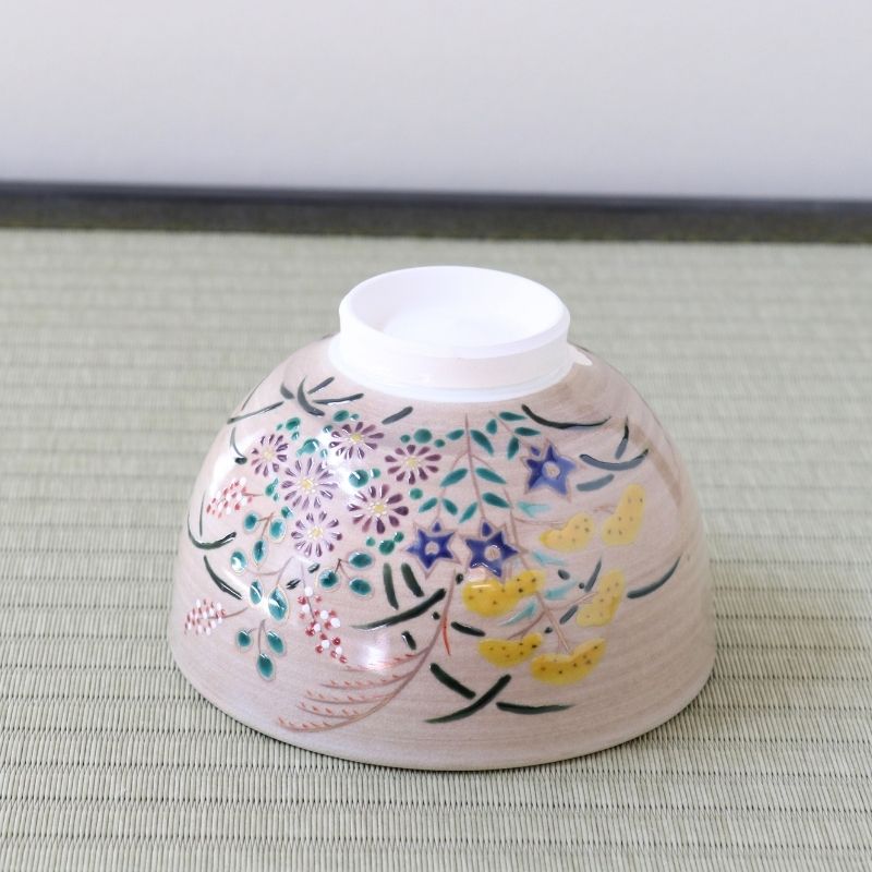 Underside view of the Kyo-yaki Akikusa matcha bowl showing its ceramic foot and hand-painted autumn flowers, grasses, and gold accents
