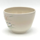 Angled view of the Kyo-yaki Akikusa ni Usagi chawan showing its rounded profile, ivory glaze, and partial hand-painted rabbit and autumn grass motif