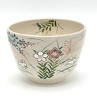 Hand-painted Kyo-yaki matcha bowl featuring the Akikusa ni Usagi motif with white rabbits, autumn grasses, flowers, and delicate green leaves on a warm ivory glaze