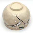 Underside view of the Kyo-yaki Eda ni Suzume matcha bowl showing its ceramic foot and hand-painted dark branches, green leaves, and sparrow decoration