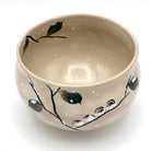 Top interior view of the Kyo-yaki Eda ni Suzume chawan showing its warm beige glaze and hand-painted branch and green leaf decoration around the rim