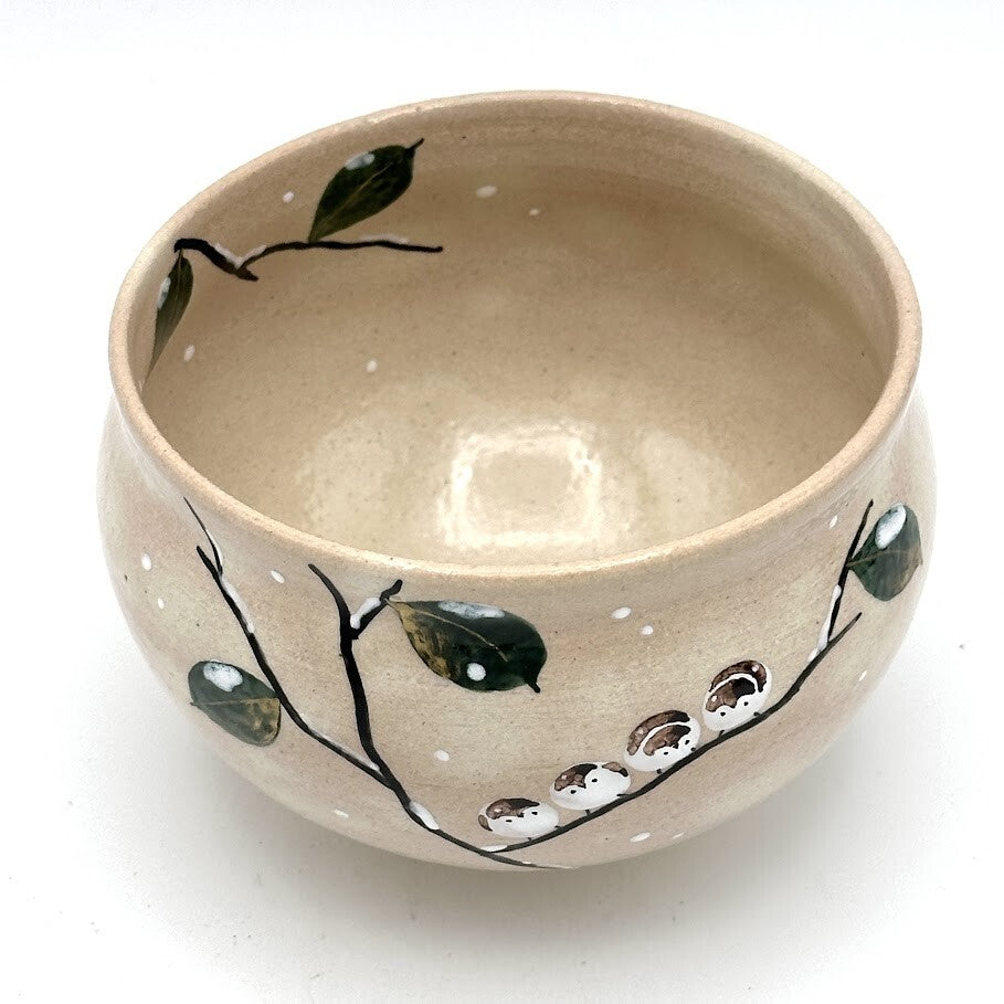 Top interior view of the Kyo-yaki Eda ni Suzume chawan showing its warm beige glaze and hand-painted branch and green leaf decoration around the rim