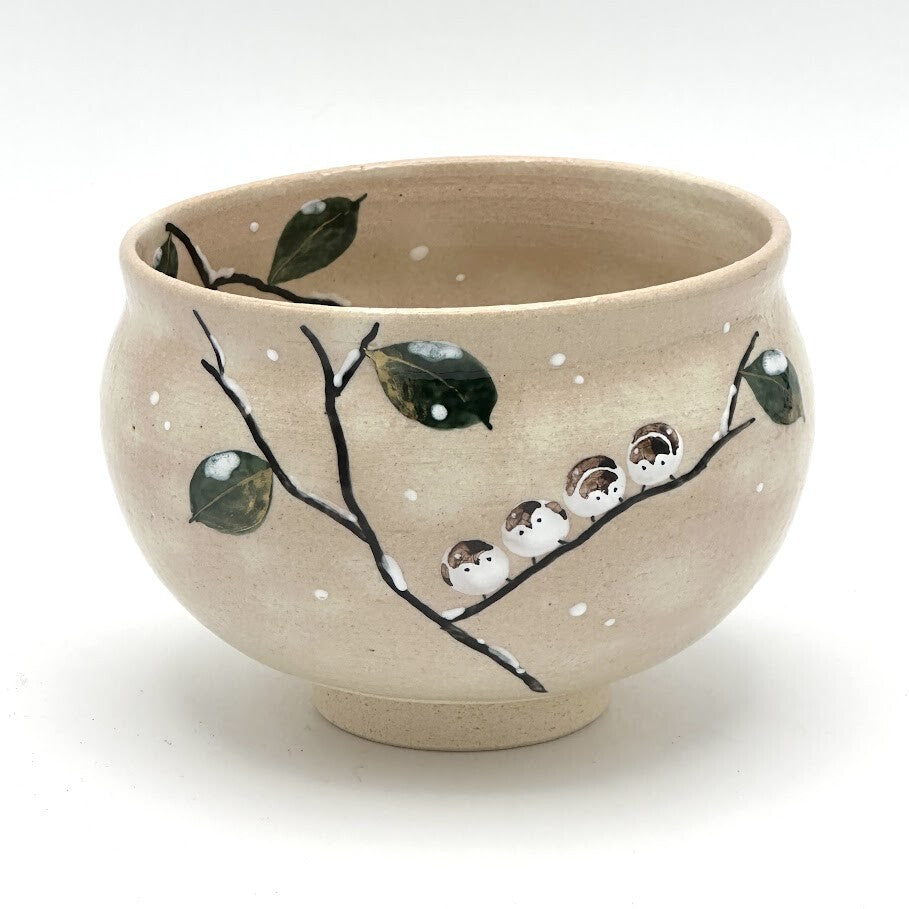 Hand-painted Kyo-yaki matcha bowl featuring the Eda ni Suzume motif with small sparrows perched on a dark branch, green leaves, and white accents on a warm beige glaze