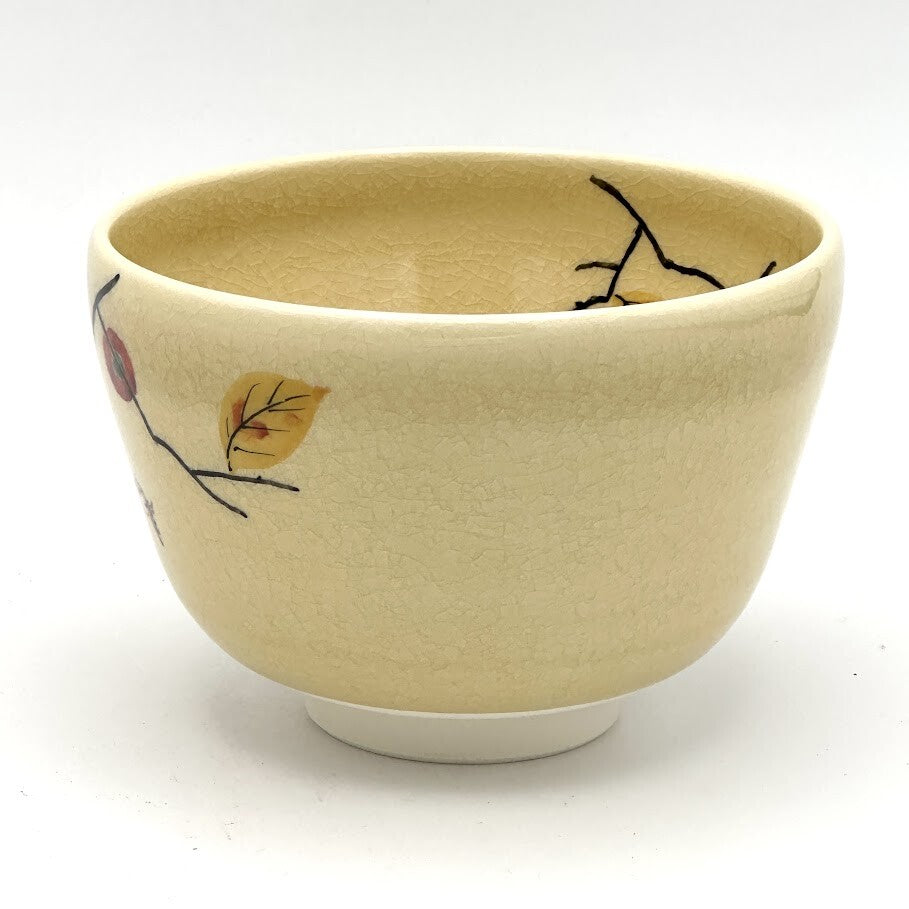 Angled view of the Kyo-yaki Kaki ni Suzume chawan showing its rounded profile, beige glaze, and partial hand-painted persimmon and sparrow motif
