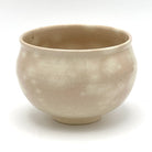 Reverse view of the Kyo-yaki Momiji Ryusui matcha bowl highlighting its rounded form and softly mottled warm beige glazed surface