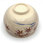 Underside view of the Kyo-yaki Momiji Ryusui matcha bowl showing its ceramic foot and hand-painted red maple leaves with blue flowing water
