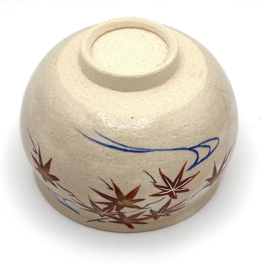 Underside view of the Kyo-yaki Momiji Ryusui matcha bowl showing its ceramic foot and hand-painted red maple leaves with blue flowing water