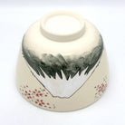 Underside view of the Kyo-yaki Mt. Fuji chawan showing its ceramic foot, hand-painted mountain landscape, and pink blossom decoration