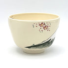 Side view of the hand-painted Kyo-yaki matcha bowl showing pink blossoms and part of the Mt. Fuji landscape against the ivory glaze