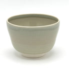 Reverse view of the Kyo-yaki Sakurazume matcha bowl highlighting its rounded form and softly textured beige glazed surface