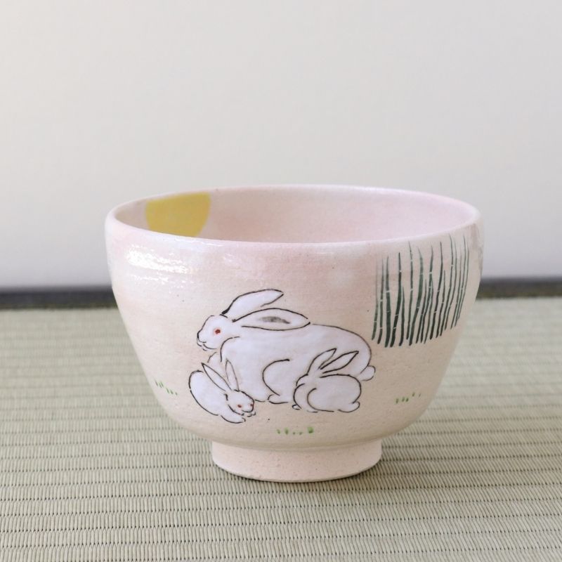 Kyo-yaki Tsukimi matcha bowl featuring a parent and child rabbit beneath a full moon with green grass details on a soft pink glaze