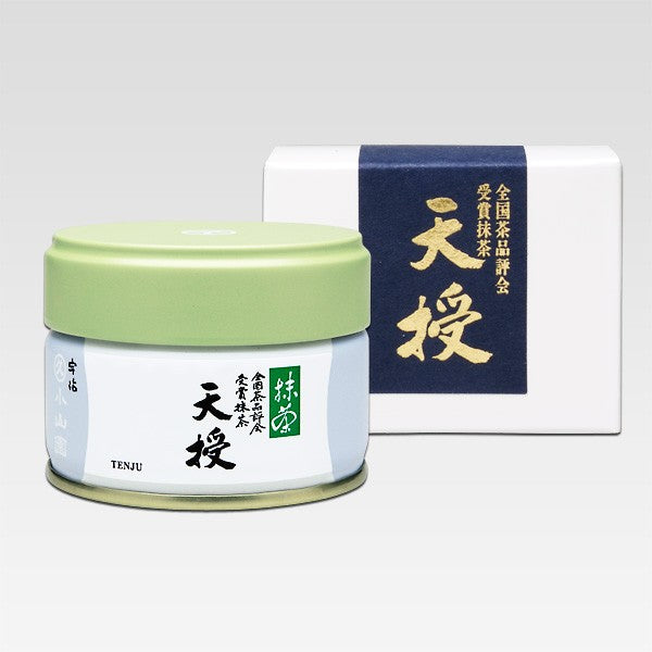 TENJU Ceremonial Grade Matcha of marukyu koyamaen in a small green canister with a white label, alongside its packaging box which has Japanese characters and branding.