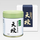 TENJU Ceremonial Grade Matcha of marukyu koyamen in a small green canister with a white label, alongside its packaging box which has Japanese characters and branding.