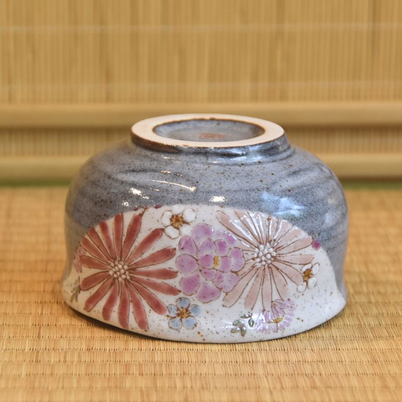 Ceramic container with floral design on a woven mat background