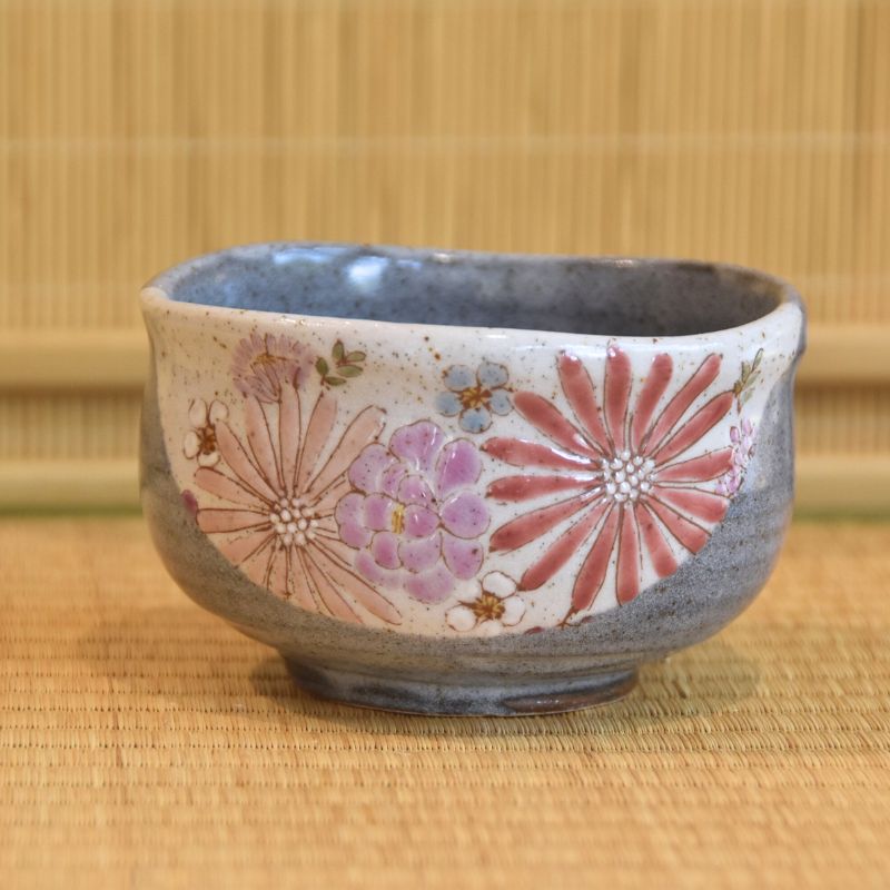 Ceramic bowl with floral patterns on a woven mat background