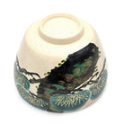 Underside view of the Matsu Kyo Ware chawan showing its ceramic foot and hand-painted pine decoration