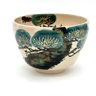 Hand-painted Kyo Ware matcha bowl featuring a traditional Matsu pine motif with deep green foliage and detailed pine needles