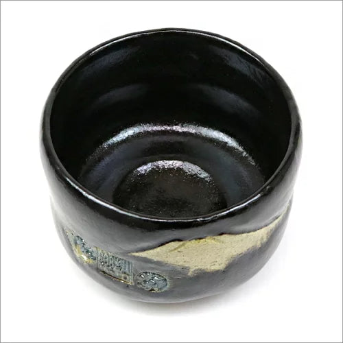 Angled top view of the Black Raku matcha bowl showing its deep glossy interior and Mt. Fuji decoration continuing around the exterior.