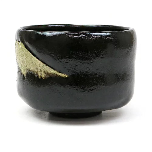 Side view of the Matsuraku Kiln matcha bowl highlighting the broad gold-toned Mt. Fuji motif against the black glaze.