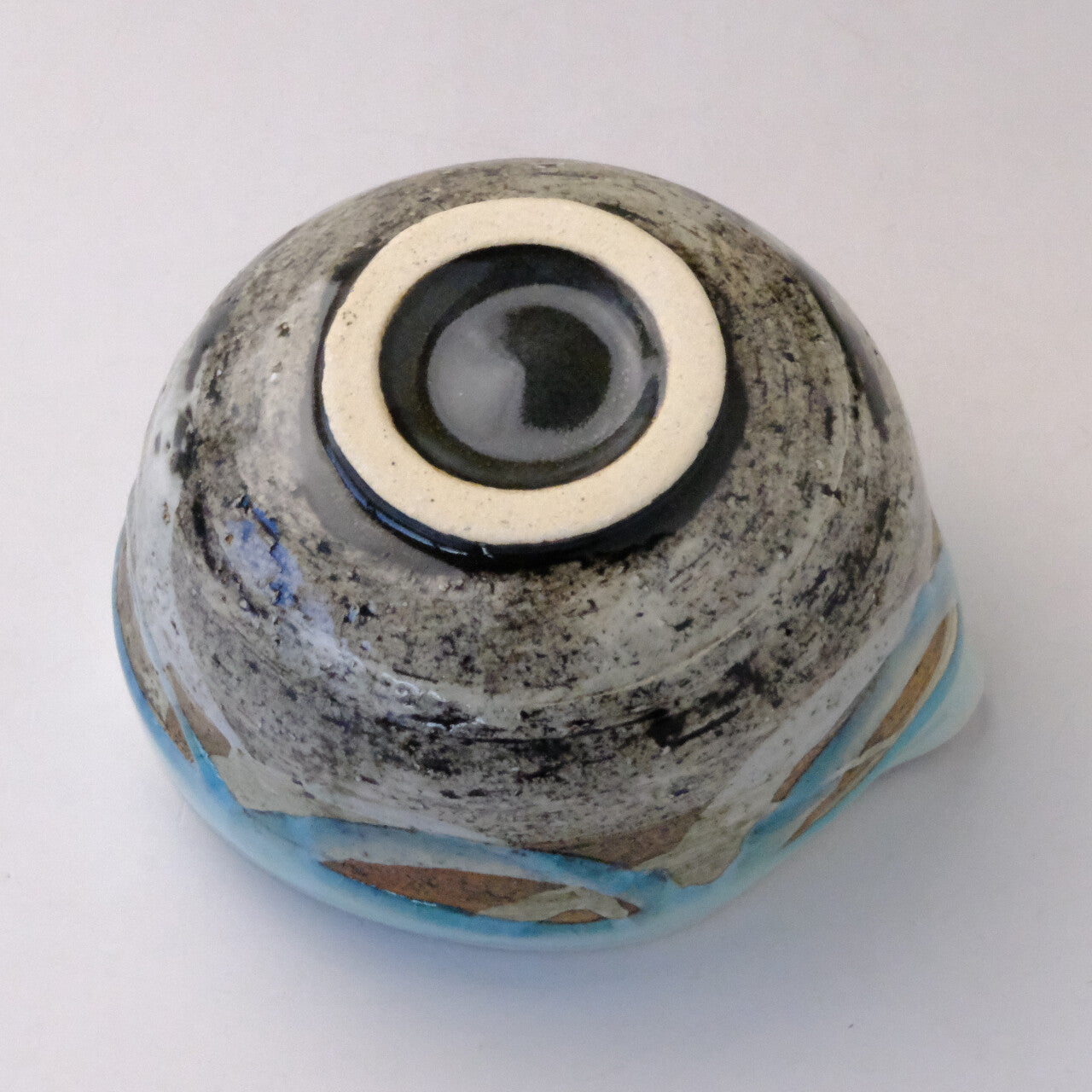 Underside view of the mint blue katakuchi matcha bowl showing the foot ring and textured glaze around the base.