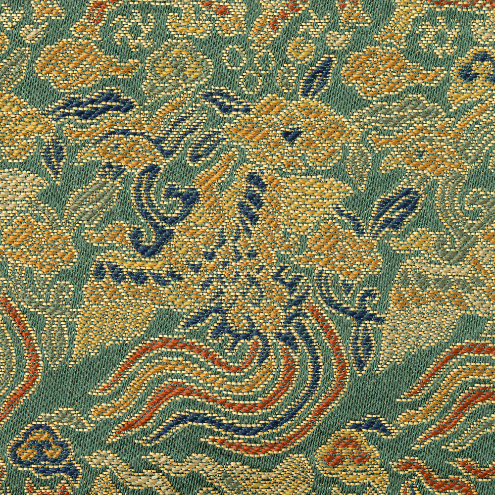 Close-up of the Nishijin silk brocade showing gold kirin and phoenix motifs among flowing multicolored clouds.