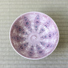 Top view of Morisato Touraku Hira Chawan showing radiating purple and turquoise floral patterns inside