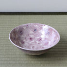 Angled view of the Morisato Touraku Hira Chawan showing its soft purple interior and delicate floral motifs