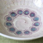 Close-up of the intricate purple and turquoise floral decoration inside the Morisato Touraku Hira Chawan