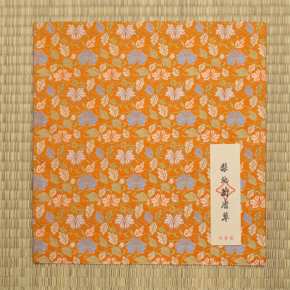 Nashi-ji Kiku Karakusa Nishijin silk dashibukusa displayed on tatami with its Japanese paper title label.