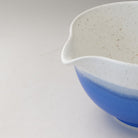 Close-up of the pouring spout on the Ocean Blue Mino Ware matcha latte bowl showing the white speckled glaze and blue exterior