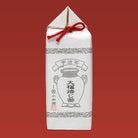 White tea package with black design and red string on a red background