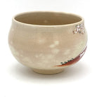 Right-side view of the Kyo Ware matcha bowl with cherry blossoms near the rim and part of the painted Red Fuji landscape.