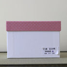 White presentation box with a pink patterned lid and product label for the red and white plum blossom matcha bowl.