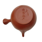 Red ceramic teapot with a lid on a white background