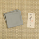 Rikyunezumi Stone Gray silk fukusa displayed on tatami with Kitamura Tokusai label
