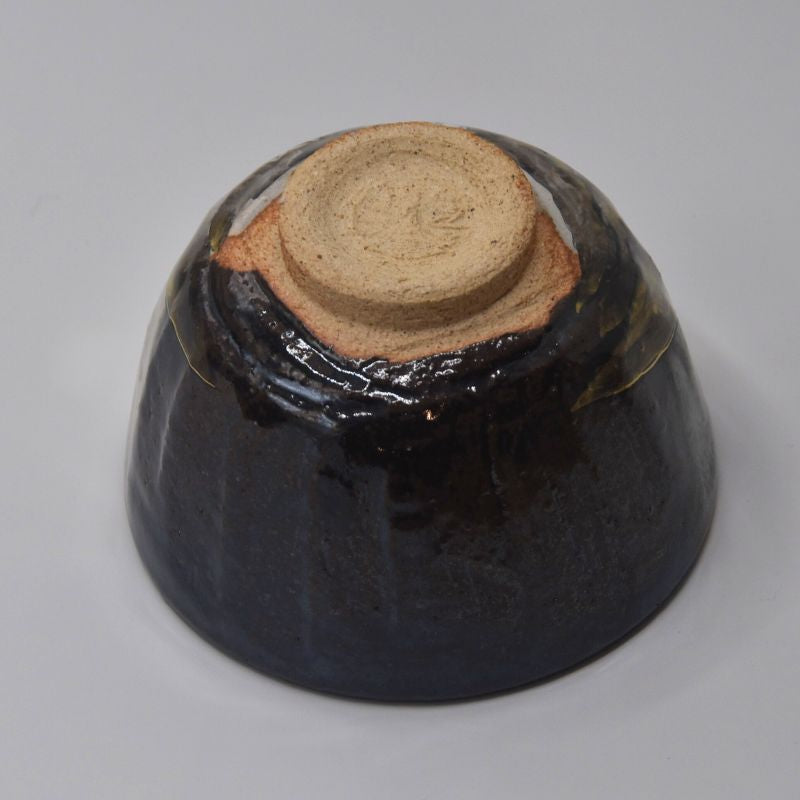 Underside view of the Kyo Ware matcha bowl showing the exposed clay foot surrounded by dark charcoal-brown glaze.